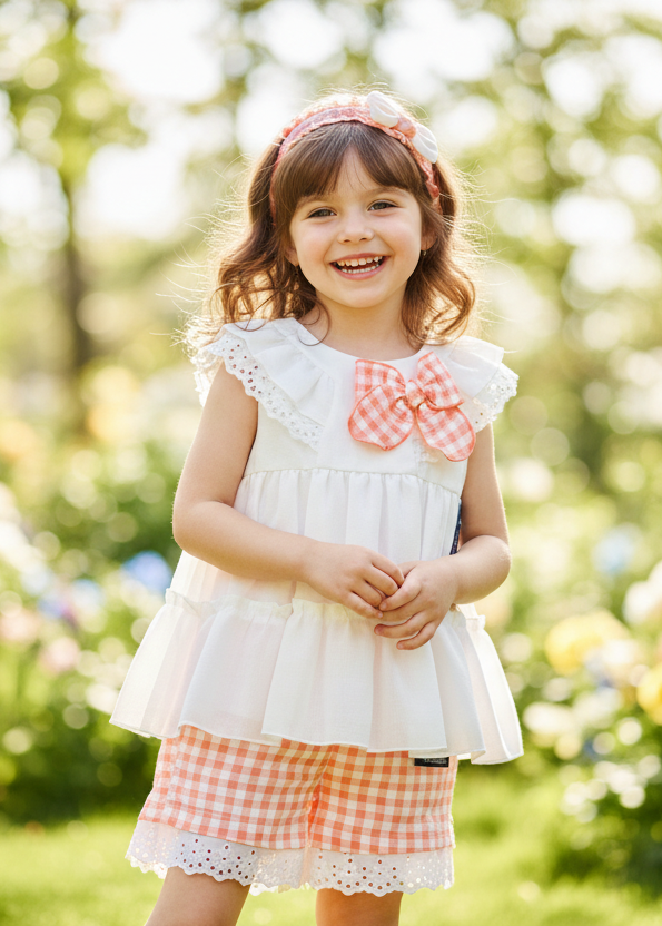 Little girl in coral gingham and white short set with headband