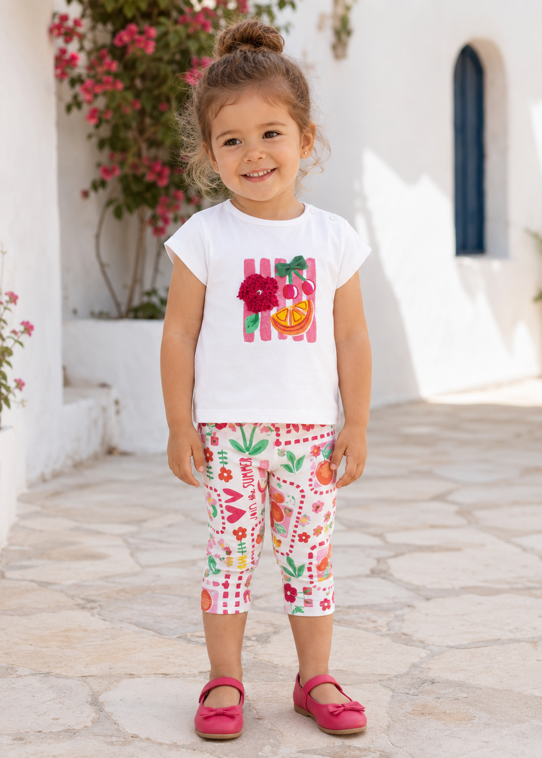 Toddler girl wearing the Mayoral Hibiscus T-shirt and printed cropped leggings in Spain