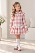 Girl wearing Miranda dusky pink Vichy check drop waist dress with frill collar and shoulder detail