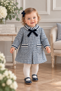 Baby girl wearing Miranda navy tweed A-line dress with velvet bow and trimmed pockets