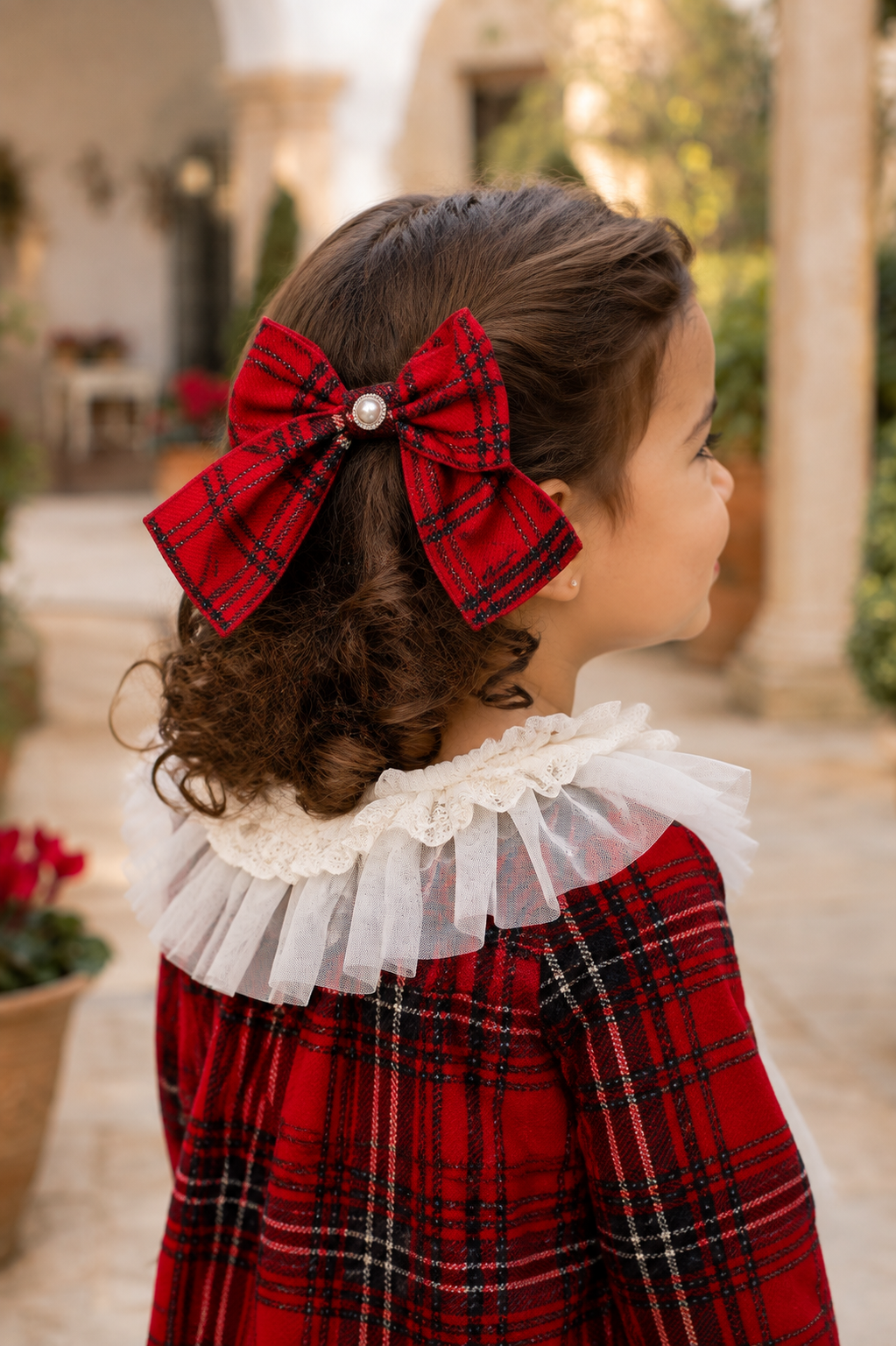 Little girl wearing the Naxos red tartan hair bow with pearl centre