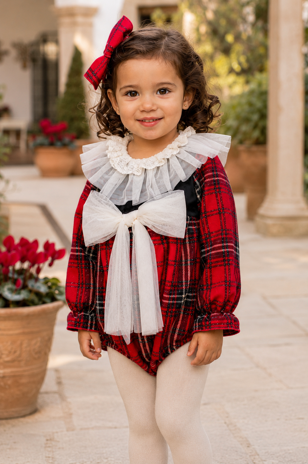 Close-up of the Naxos red tartan romper with cream tulle collar and bow