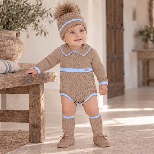 Baby boy wearing the Rahigo camel and powder baby blue knitted romper set with pom pom hat and knee-high socks