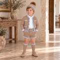 Young boy wearing the Rahigo camel and powder baby blue five-piece short set with pom pom hat and knee-high socks